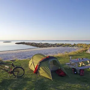 Camping on a quiet beach at dusk with tent Camping on a quiet beach at dusk with tent
