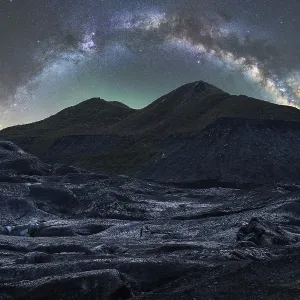 Paysage icelandais captivant sous un ciel étoilé impressionnant La Voie lactée se déroule gracieusement au-dessus, illuminant le paysage accidenté avec une lumière surnaturelle.