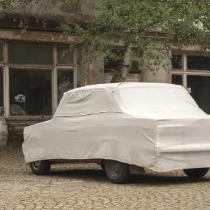 Car cover on obsolete vintage car closeup Car cover on obsolete vintage car closeup