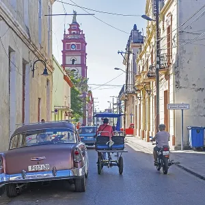 Cathedral, vintage American classic car and bicitaxi