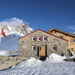 Chamanna d'Es-cha mountain hut in a wintry mountain landscape