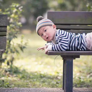 Child lying on a bench in the park