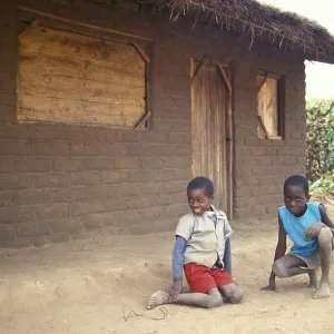 Children in front of a clay hut on the side of the road Children in front of a clay hut on the side of the road