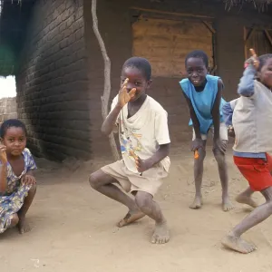 Children in front of a clay hut on the side of the road Children in front of a clay hut on the side of the road