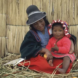 Children sitting in front of a reed hut on a floating Uro island in Lake Titcaca