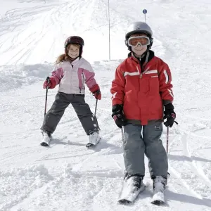 Two children skiing in the mountains