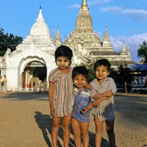 Children with Thanaka paste on their faces in front of Buddhist pagodas