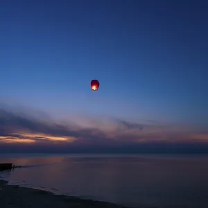 Chinese lantern flying over the calm sea at night