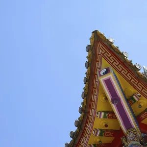 Chinese temple roof with golden decoration under blue sky
