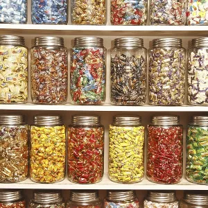Chocolates kept in different glass jars on selves in shop