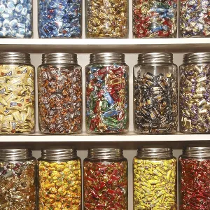 Chocolates kept in different glass jars on selves in shop