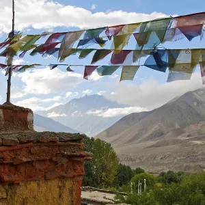 The Chorten and prayer flags on a background of mountains and clouds