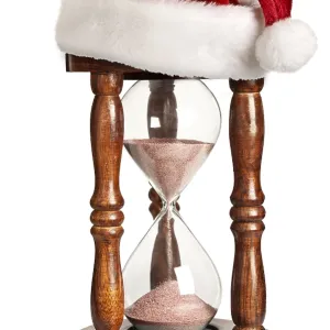 Christmas is coming concept, hourglass with Santa Claus hat isolated on white background Christmas is coming concept, hourglass with Santa Claus hat isolated on white background