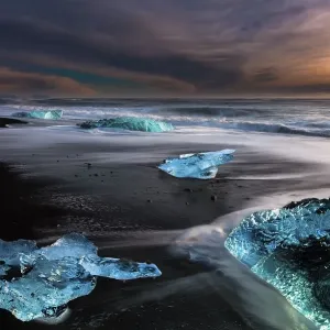Chunks of ice on black lava sand beach at sunrise Chunks of ice on black lava sand beach at sunrise