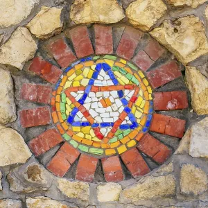 Circular mosaic religious symbol Star of David on stone wall Circular mosaic religious symbol Star of David on stone wall