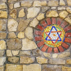 Circular mosaic religious symbol Star of David on stone wall Circular mosaic religious symbol Star of David on stone wall