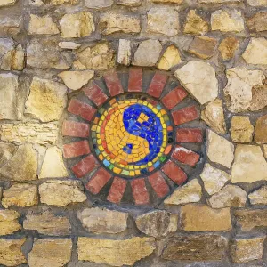 Circular mosaic religious symbol of Yin and yang on stone wall Circular mosaic religious symbol of Yin and yang on stone wall