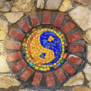Circular mosaic religious symbol of Yin and yang on stone wall Circular mosaic religious symbol of Yin and yang on stone wall
