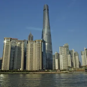 City skyline of Huangpu Jiang with tall modern buildings against blue sky on the water