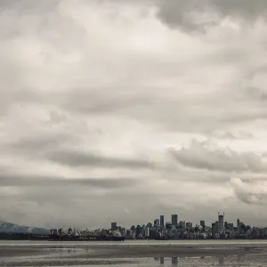 City skyline with towering buildings under a cloud-filled sky City skyline with towering buildings under a cloud-filled sky