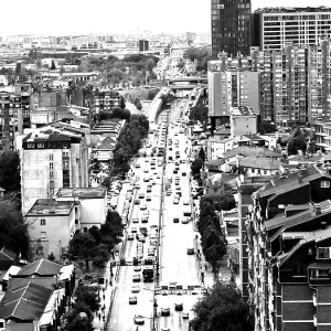 City view of a busy street with skyscrapers in the background in black and white