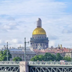 City view with golden dome and bridge over water under blue sky