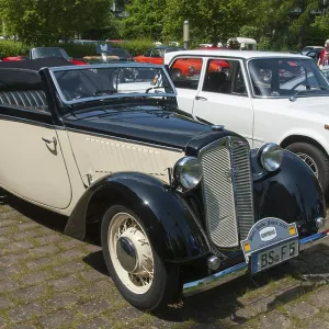 Classic black and white vintage car in an open-air car park with other vintage cars in the background Classic black and white vintage car in an open-air car park with other vintage cars in the background
