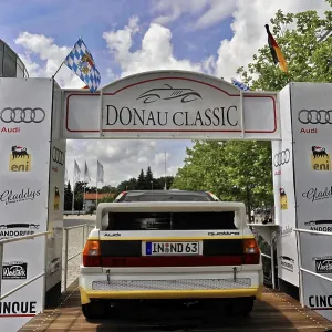 Classic car at the Donau Classic in front of a starting point with flags Classic car at the Donau Classic in front of a starting point with flags