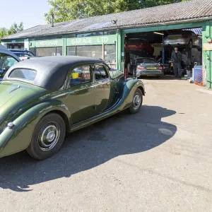 Classic vintage car on forecourt of village car mechanics garage Classic vintage car on forecourt of village car mechanics garage