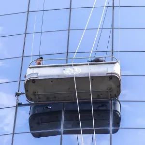 Two cleaners washing the windows of modern skyscraper in New York Two cleaners washing the windows of modern skyscraper in New York