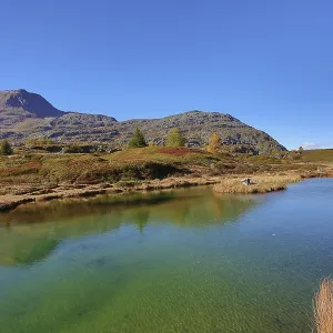 Clear mountain lake landscape in autumn colors under blue sky