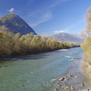 Clear river with gravel bank between autumn trees