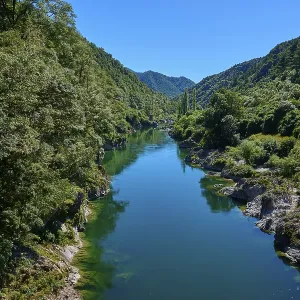 Clear river between wooded hills