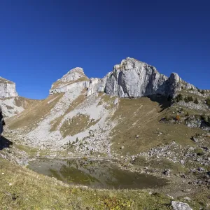 Cliffs at Tour de Mayen with a small mountain lake Lac de Mayen