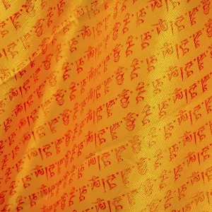 Close up of buddhist prayers on the yellow orange praying flag Close up of buddhist prayers on the yellow orange praying flag