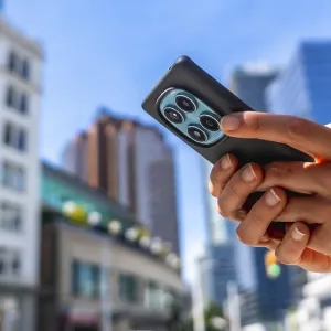 Close up of hands holding smartphone with multiple camera lenses