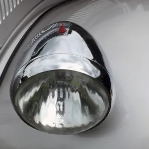 Close up of the headlamp of an elegant silver colored stylish 1930s vintage automobile Close up of the headlamp of an elegant silver colored stylish 1930s vintage automobile