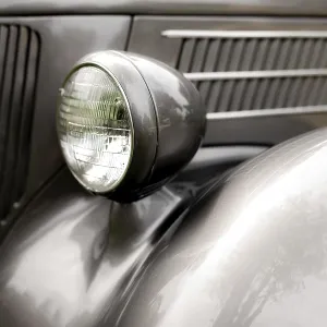 Nahaufnahme eines klassischen Autoscheinwerfers in Chrom auf einem schwarzen Leib in St.