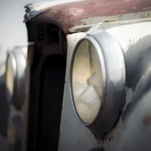 Close-up of a classic Jaguar car's weathered headlights
