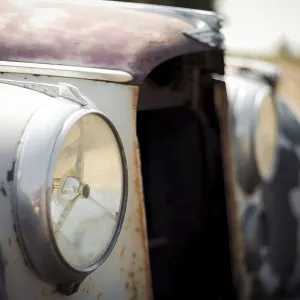 Close-up of a rusty vintage Jaguar car headlight and front body