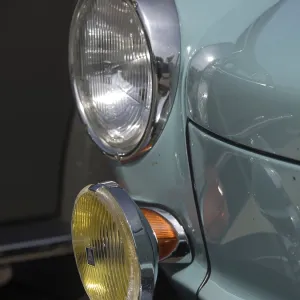 Close-up of a turquoise classic car with additional yellow headlights and chrome accents Close-up of a turquoise classic car with additional yellow headlights and chrome accents