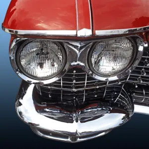 Close-up of twin headlights and bumper of an American road cruiser with red paintwork