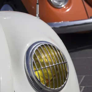 Close-up of a white classic car with yellow headlight Close-up of a white classic car with yellow headlight