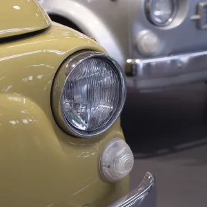 Close-up of a yellow vintage car with shiny chrome headlights