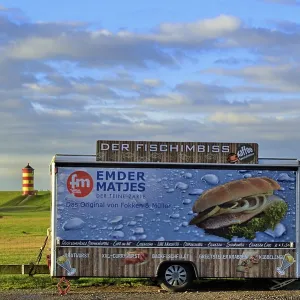 Closed fish snack car stands on the car park in front of the Pilsum lighthouse