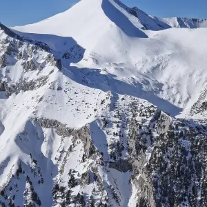 Closeup view to the rocky mountain peak covered with snow Closeup view to the rocky mountain peak covered with snow