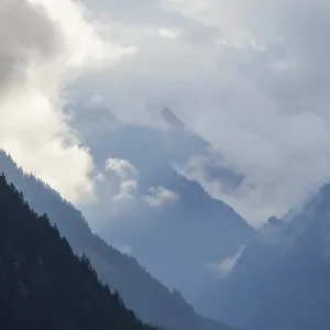 Cloudy atmosphere with forest and mountains