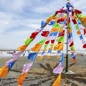 Colorful tibetan buddhist praying flags in the wind next to Chaqia salt lake Colorful tibetan buddhist praying flags in the wind next to Chaqia salt lake