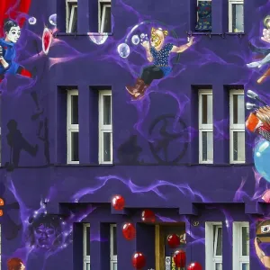 A colorful wall painting with surreal circus motifs adorns a house facade in Dusseldorf's Flingern