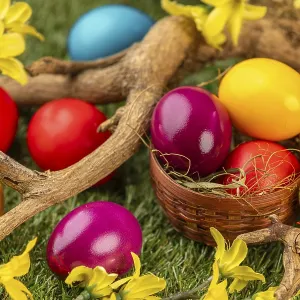 Colourful Easter eggs in and around a small basket